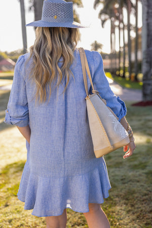 Woman wearing UPF 50+ blue button down mini dress with sun protection at the country club