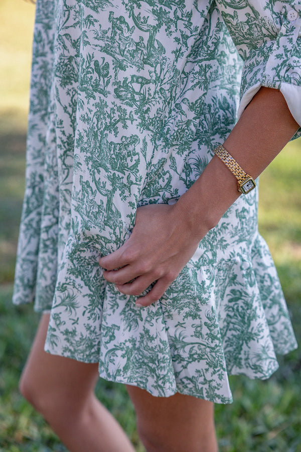 Close up of a woman wearing UPF 50+ floral green button down mini dress with sun protection at the country club