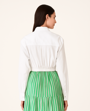 Woman wearing Crisp white UPF 50+ top and green skirt with sun protection on a white background