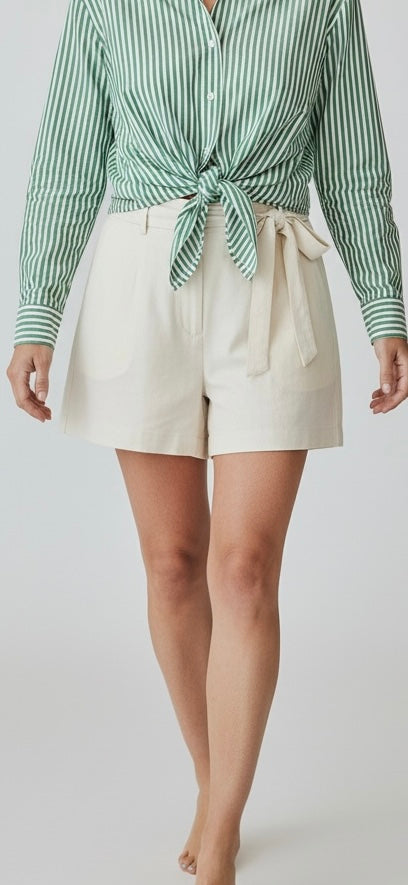 Woman wearing white UPF 50+ shorts and green strip top with sun protection on a white background